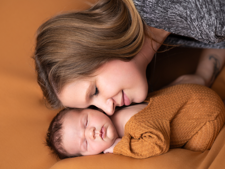 Neugeborenen-Fotoshooting im Studio. Mama und Baby liebevoll beieinander.